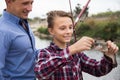 Young man with son looking at fish on hook Royalty Free Stock Photo