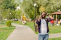 The young man is speaking at his cell phone at the park. Royalty Free Stock Photo