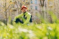 A young man in special construction clothing. Sad builder is sitting on the grass in a helmet. Rest break from work Royalty Free Stock Photo