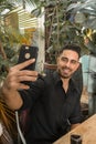 young man spending time in outdoor restaurant having a cocktail and taking selfie Royalty Free Stock Photo