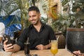 young man spending time in outdoor restaurant having a cocktail and taking selfie Royalty Free Stock Photo