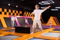 Young man in sport clothes high jumping in trampoline arena