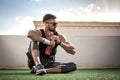 Young man in sports clothing with sunglasses take a break after training at rooftop gym Royalty Free Stock Photo