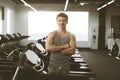 Young man in sportswear smiling and standing near the treadmill before or after training on gym. Cardio workout, running Royalty Free Stock Photo