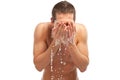 Young man spraying water on his face after shaving in the bathroom Royalty Free Stock Photo