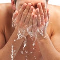 Young man spraying water on his face after shaving in the bathroom Royalty Free Stock Photo