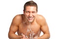 Young man spraying water on his face after shaving in the bathroom Royalty Free Stock Photo