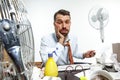 Young man ssuffering from the heat in the office