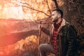 Young man standing alone holding the wooden stick and looking over the lake Royalty Free Stock Photo