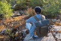 Young man standing alone outdoor with wild forest on background. Royalty Free Stock Photo