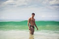 Young man standing on beach by the ocean