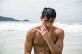 Young man standing on beach by the ocean Royalty Free Stock Photo