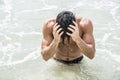 Young man standing on beach by the ocean Royalty Free Stock Photo