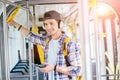 Young man is standing in a bus with headset on his head and listening to the music
