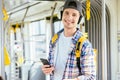 Young man is standing in a bus with headset on his head and listening to the music Royalty Free Stock Photo