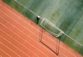 Young man standing in the center of a soccer field with a net and goal in the background Royalty Free Stock Photo