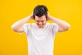 Young man standing he covering his ears with hands and shouting opened mouth shriek