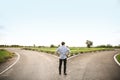 Young man standing at crossroads. Concept of choice Royalty Free Stock Photo