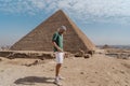 young man standing in the desert with Keops pyramid in the background. El Cairo. Egypt