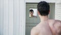 Young Man Standing in Doorway of Rustic Beach Hut Royalty Free Stock Photo