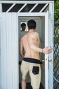 Young Man Standing in Doorway of Rustic Beach Hut Royalty Free Stock Photo