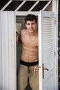 Young Man Standing in Doorway of Rustic Beach Hut Royalty Free Stock Photo