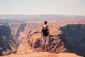 Young man standing at the edge of the Horse Shoe Bend cliff Royalty Free Stock Photo