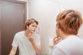 Young man standing in front of mirror and touching his face Royalty Free Stock Photo