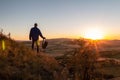 Young man standing on hill and hold backpack looking to Czech ore mountain valley at sunset landscape Royalty Free Stock Photo