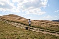 Young man standing on the hill of the mountain. Feeling happy and free. Natural landscape in summer. Sunny rural scenery. Nature Royalty Free Stock Photo