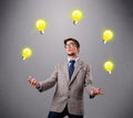 Young man standing and juggling with light bulbs Royalty Free Stock Photo