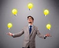 Young man standing and juggling with light bulbs Royalty Free Stock Photo