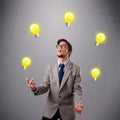 Young man standing and juggling with light bulbs Royalty Free Stock Photo