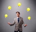 Young man standing and juggling with light bulbs Royalty Free Stock Photo