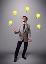 Young man standing and juggling with light bulbs Royalty Free Stock Photo