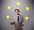 Young man standing and juggling with light bulbs Royalty Free Stock Photo