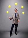 Young man standing and juggling with light bulbs Royalty Free Stock Photo