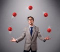 Young man standing and juggling with red balls Royalty Free Stock Photo