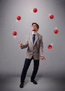 Young man standing and juggling with red balls Royalty Free Stock Photo