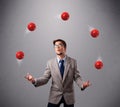 Young man standing and juggling with red balls Royalty Free Stock Photo