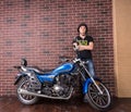 Young Man Standing Beside Motorcycle Against Wall