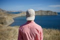 Young man standing on a mountain shore looking to the sea