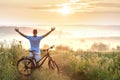 Young man standing near bicycle in morning sunrise with wonderf Royalty Free Stock Photo