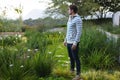 Young man standing near flowers in the garden Royalty Free Stock Photo