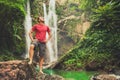 Young man standing near a waterfall in forest Royalty Free Stock Photo