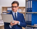 Young man standing next to the shelf with folders Royalty Free Stock Photo