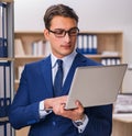 Young man standing next to the shelf with folders Royalty Free Stock Photo