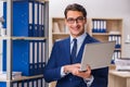 The young man standing next to the shelf with folders Royalty Free Stock Photo