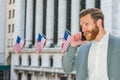 Young man standing outside office building in New York City, talking on cell phone Royalty Free Stock Photo