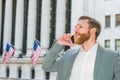 Young man standing outside office building in New York City, talking on cell phone Royalty Free Stock Photo